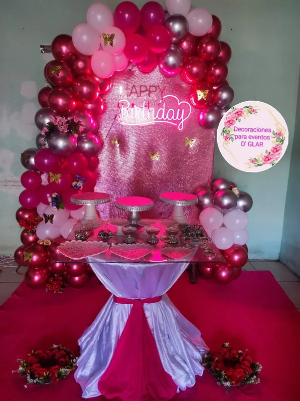 Arco de globos fucsia con mesa de torta iluminada