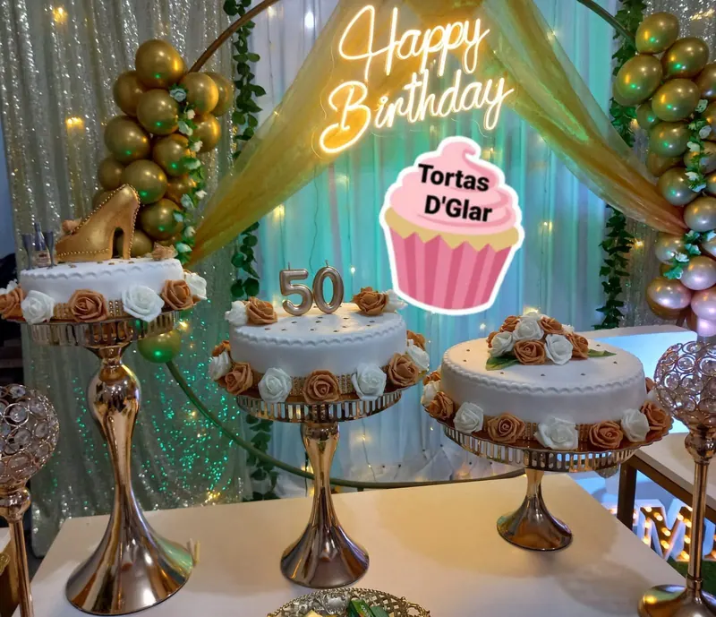 Mesa de dulces montada con bandejas doradas y cortina de fondo